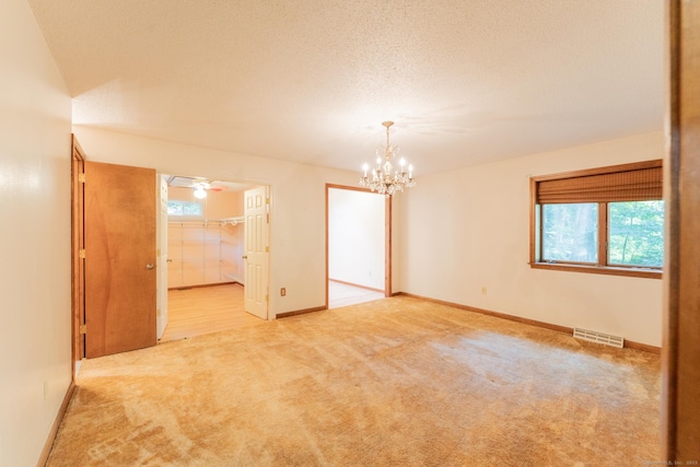 54 Timber Ln, Avon, CT 06001 - empty room featuring carpet floors, plenty of natural light, a chandelier, and a textured ceiling