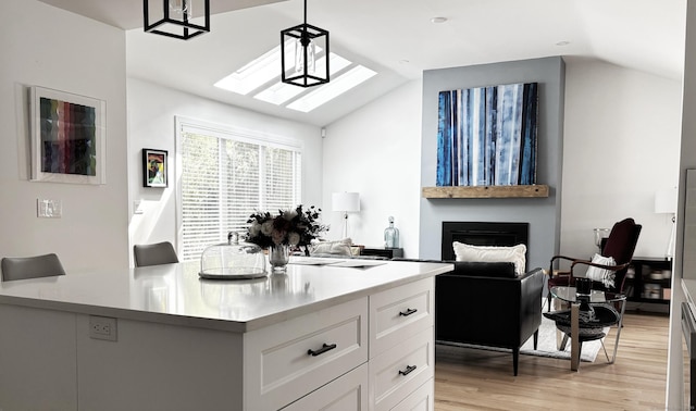 27 Mary Ln, Greenwich, CT 06878 - kitchen with vaulted ceiling, light wood-type flooring, a skylight, white cabinetry, and light countertops