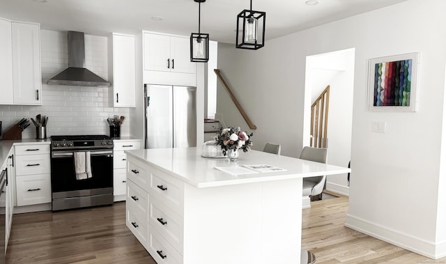 27 Mary Ln, Greenwich, CT 06878 - kitchen featuring wall chimney range hood, appliances with stainless steel finishes, tasteful backsplash, wood finished floors, and light countertops