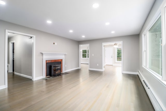 22 Lonetown Rd, Redding, CT 06896 - unfurnished living room with baseboard heating, wood finished floors, recessed lighting, ceiling fan, and a brick fireplace