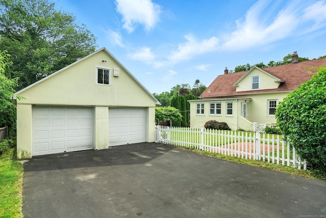 92 Yates St, West Haven, CT 06516 - view of front facade with a chimney, stucco siding, an outbuilding, and a garage