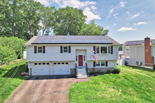 69 Sills Dr, Watertown, CT 06779 - split foyer home featuring driveway, an attached garage, a front lawn, and roof mounted solar panels