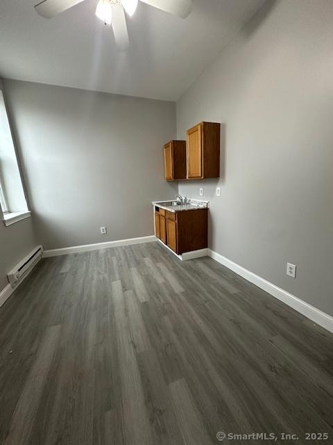 473 E Main St, Waterbury, CT 06702 - unfurnished living room with a baseboard heating unit, ceiling fan, dark wood finished floors, and vaulted ceiling