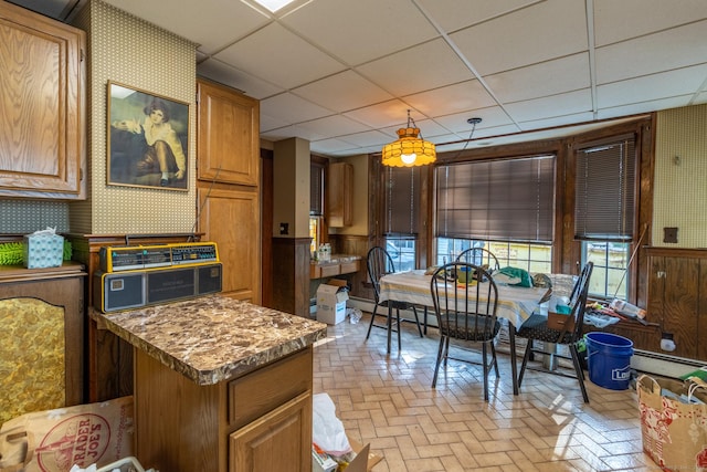 47 Ridge Rd, Middletown, CT 06457 - kitchen featuring wallpapered walls, a paneled ceiling, wainscoting, brick patterned flooring, and brown cabinets