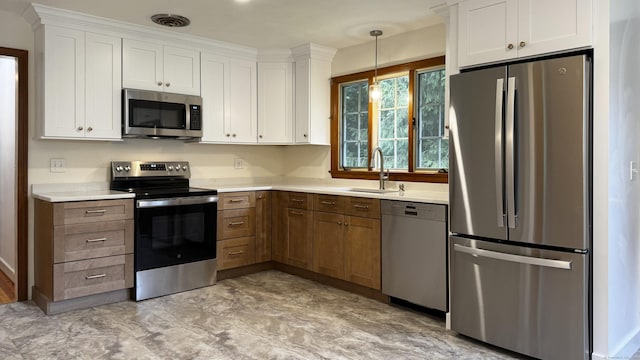 19 Eli Chapman Rd, East Haddam, CT 06469 - kitchen with stainless steel appliances, light countertops, white cabinets, and decorative light fixtures