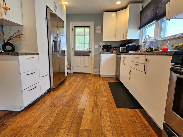 27 White Rose Ave, Waterbury, CT 06708 - kitchen featuring stainless steel appliances, light wood-style flooring, white cabinetry, dark countertops, and recessed lighting