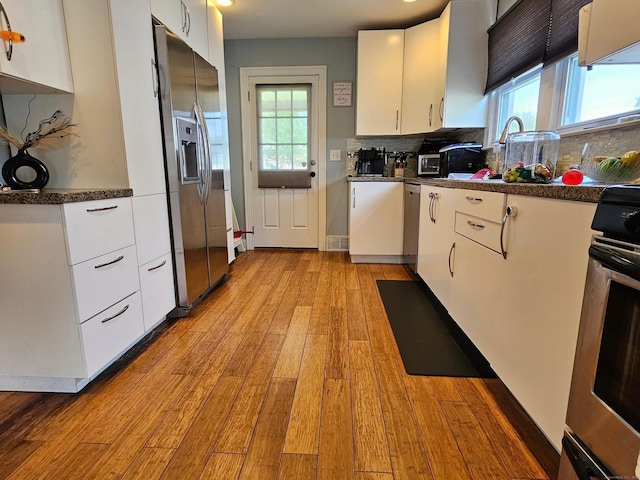 27 White Rose Ave, Waterbury, CT 06708 - kitchen with stainless steel appliances, light wood-style flooring, white cabinetry, and dark countertops