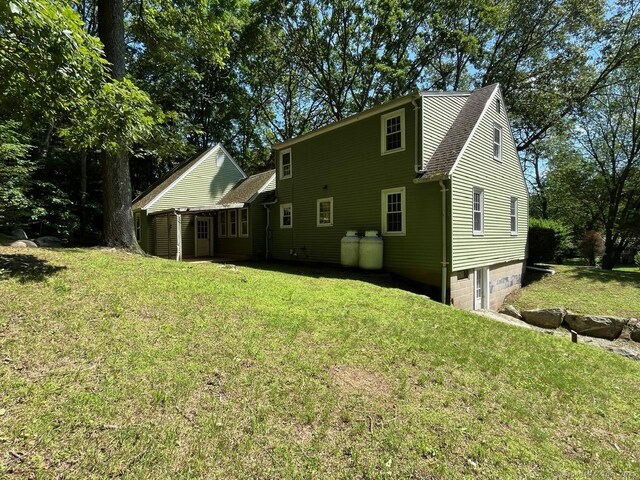 87 Mcveagh Rd, Westbrook, CT 06498 - back of property with an attached garage and a lawn