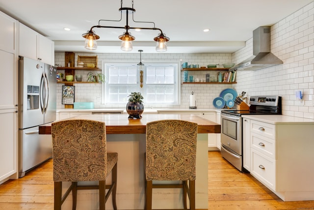 51 Moodus Leesville Rd, East Haddam, CT 06469 - kitchen with stainless steel appliances, wall chimney range hood, open shelves, a center island, and light wood-type flooring