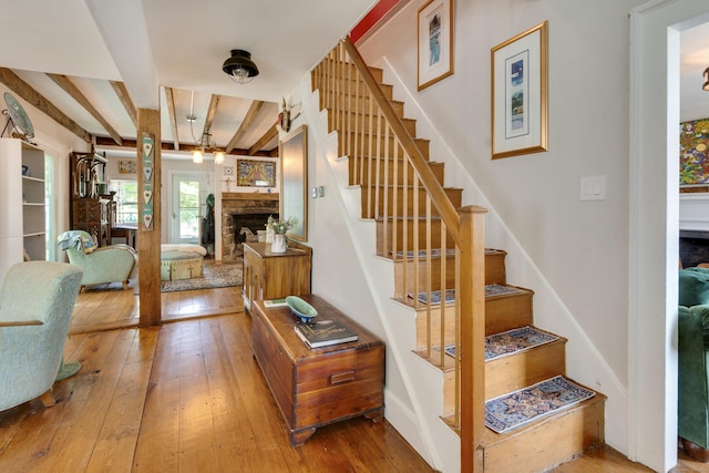 51 Moodus Leesville Rd, East Haddam, CT 06469 - stairs featuring a stone fireplace, hardwood / wood-style floors, and beamed ceiling