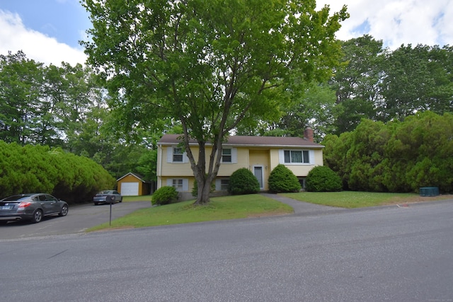 81 Birchwood Dr, Torrington, CT 06790 - raised ranch featuring a chimney, an outbuilding, a front lawn, and a garage
