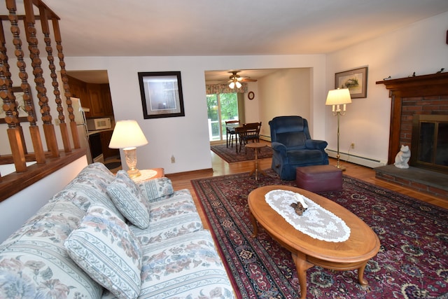 81 Birchwood Dr, Torrington, CT 06790 - living room featuring baseboard heating, wood finished floors, a brick fireplace, and a ceiling fan