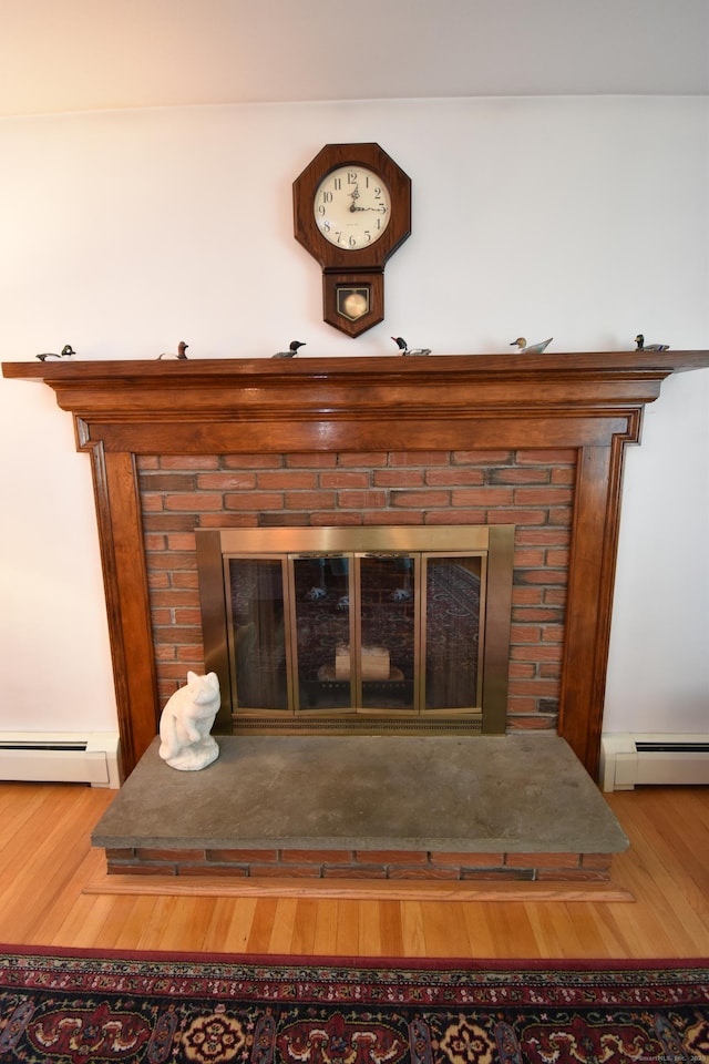 81 Birchwood Dr, Torrington, CT 06790 - detailed view of baseboard heating, wood finished floors, and a fireplace