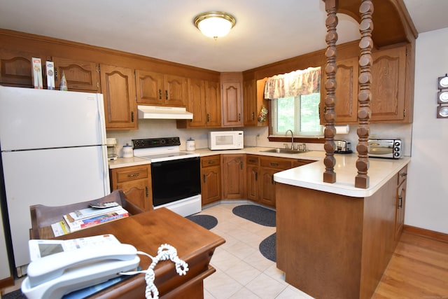 81 Birchwood Dr, Torrington, CT 06790 - kitchen featuring white appliances, under cabinet range hood, brown cabinetry, a peninsula, and light countertops