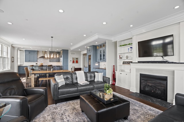 66 High St Unit 31, Guilford, CT 06437 - living room featuring dark wood finished floors, a chandelier, crown molding, recessed lighting, and a fireplace