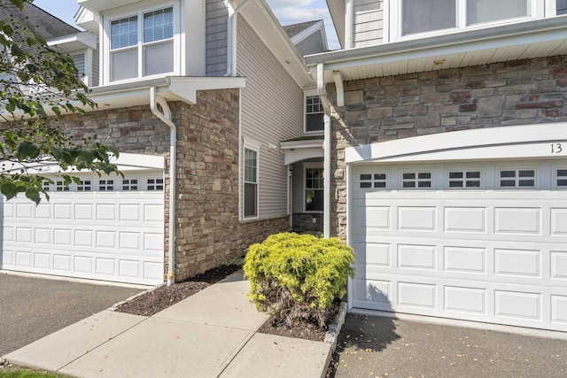 12 Sampson Ter Unit 12, Danbury, CT 06810 - view of property exterior with stone siding, an attached garage, and driveway