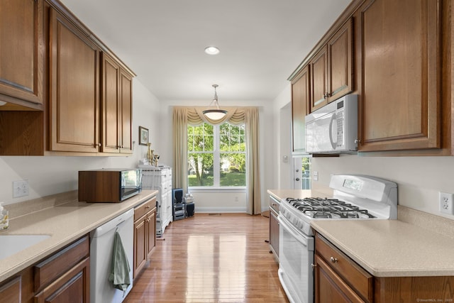 12 Sampson Ter Unit 12, Danbury, CT 06810 - kitchen with white appliances, light wood-style flooring, light countertops, recessed lighting, and brown cabinetry