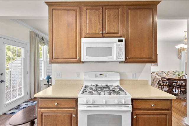 12 Sampson Ter Unit 12, Danbury, CT 06810 - kitchen featuring white appliances, ornamental molding, brown cabinetry, light countertops, and a chandelier