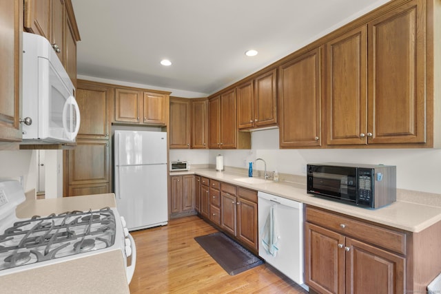 12 Sampson Ter Unit 12, Danbury, CT 06810 - kitchen featuring white appliances, recessed lighting, brown cabinets, light wood-style flooring, and light countertops