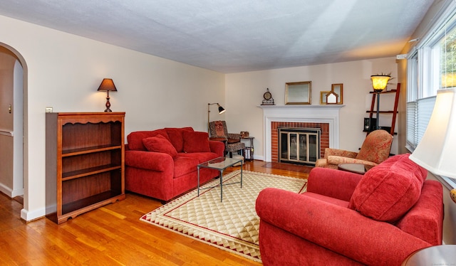 49 Remington Rd, Windsor, CT 06095 - living room featuring arched walkways, wood finished floors, and a brick fireplace