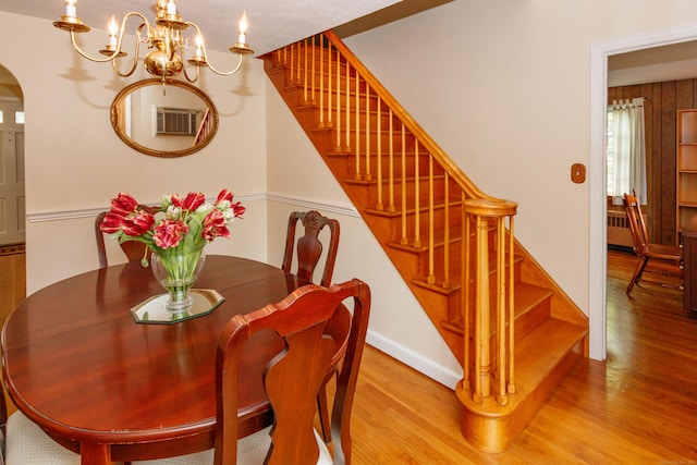 49 Remington Rd, Windsor, CT 06095 - dining area featuring wood finished floors, arched walkways, a chandelier, radiator heating unit, and stairway