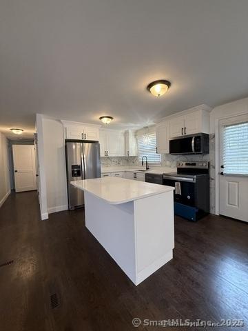 90 Diane Dr, South Windsor, CT 06074 - kitchen with stainless steel fridge with ice dispenser, electric stove, white cabinets, and dark wood finished floors
