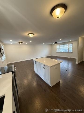 90 Diane Dr, South Windsor, CT 06074 - kitchen featuring open floor plan, dark wood-style flooring, a kitchen island, white cabinetry, and light countertops