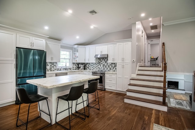 7 Derenthal Dr, Madison, CT 06443 - kitchen with stainless steel appliances, under cabinet range hood, light countertops, white cabinets, and decorative backsplash