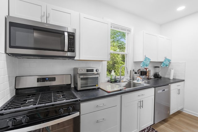 78 Pine St, Waterbury, CT 06710 - kitchen featuring stainless steel appliances, tasteful backsplash, white cabinets, and dark countertops