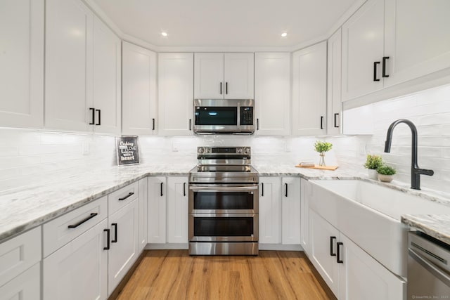 12 Boulevard Dr Unit 27-157, Danbury, CT 06810 - kitchen with stainless steel appliances, white cabinets, decorative backsplash, and recessed lighting