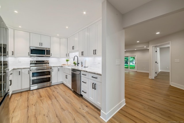 12 Boulevard Dr Unit 27-157, Danbury, CT 06810 - kitchen featuring stainless steel appliances, decorative backsplash, light wood-type flooring, white cabinets, and recessed lighting