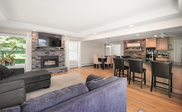 117 Woodfield Rd, Bristol, CT 06010 - living area featuring a tray ceiling, light wood-style flooring, a stone fireplace, recessed lighting, and a ceiling fan