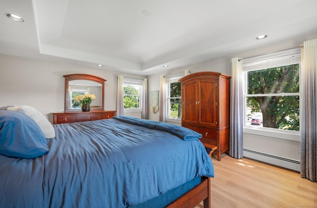 117 Woodfield Rd, Bristol, CT 06010 - bedroom featuring baseboard heating, a tray ceiling, light wood-style floors, and recessed lighting