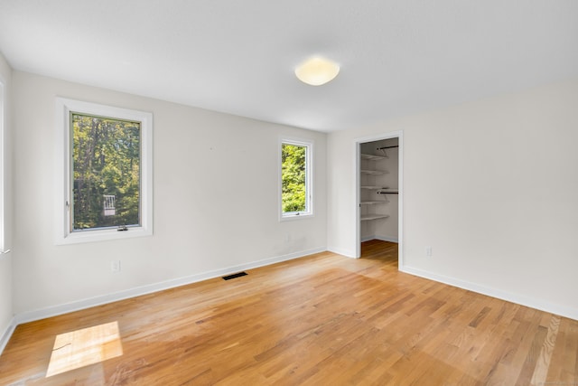 11 Island Bay Cir, Guilford, CT 06437 - unfurnished bedroom featuring light wood finished floors, a spacious closet, and a closet