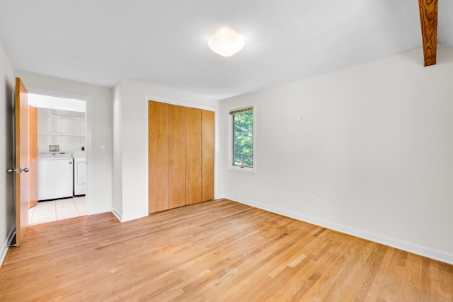 11 Island Bay Cir, Guilford, CT 06437 - unfurnished bedroom featuring washing machine and clothes dryer, light wood finished floors, and a closet