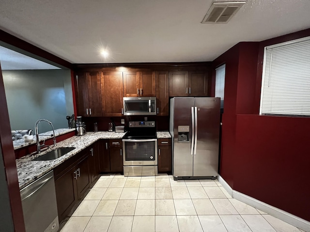 132 Maple Ave Unit B, Hartford, CT 06114 - kitchen featuring appliances with stainless steel finishes, light stone counters, light tile patterned flooring, and dark brown cabinets