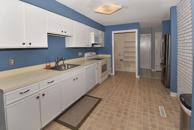 11 Thistle Way Apt D, East Windsor, CT 06016 - kitchen with white appliances, white cabinets, light countertops, light flooring, and a textured ceiling