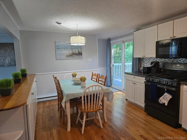 60 Spring Glen Rd, East Lyme, CT 06357 - dining room with a baseboard heating unit, wood finished floors, a textured ceiling, and a wainscoted wall