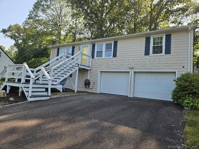 60 Spring Glen Rd, East Lyme, CT 06357 - view of front of home featuring an attached garage, asphalt driveway, and stairs