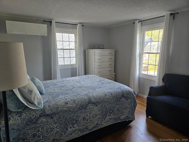 60 Spring Glen Rd, East Lyme, CT 06357 - bedroom with a wall unit AC, wood finished floors, and a textured ceiling