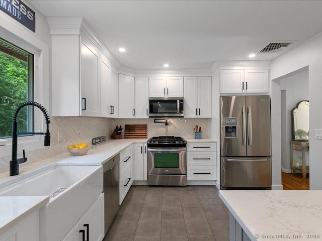 964 Red Fox Rd, Orange, CT 06477 - kitchen featuring appliances with stainless steel finishes, white cabinetry, decorative backsplash, recessed lighting, and light stone counters