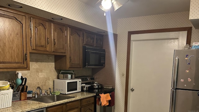 525 Jennings Ave, Bridgeport, CT 06610 - kitchen featuring stainless steel appliances, wallpapered walls, tasteful backsplash, light countertops, and a ceiling fan