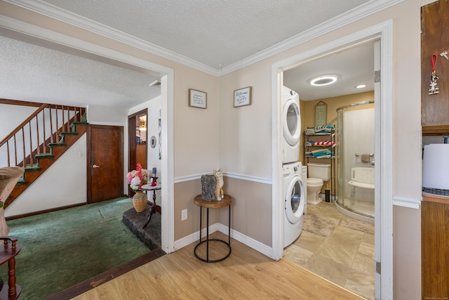 141 Peach Orchard Rd, Waterbury, CT 06706 - laundry area featuring stacked washing machine and dryer, a textured ceiling, ornamental molding, and wood finished floors