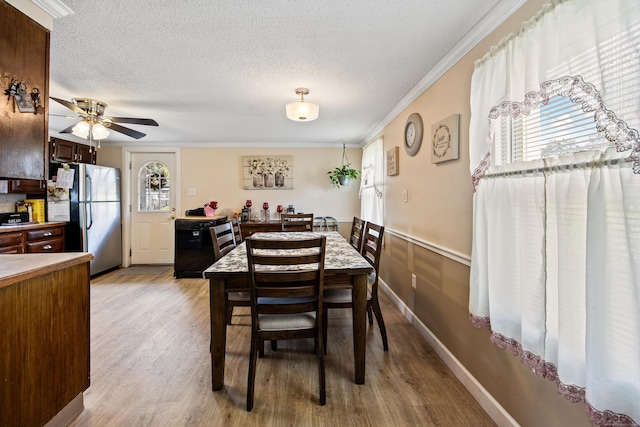 141 Peach Orchard Rd, Waterbury, CT 06706 - dining area with light wood-style flooring, a textured ceiling, ceiling fan, and crown molding