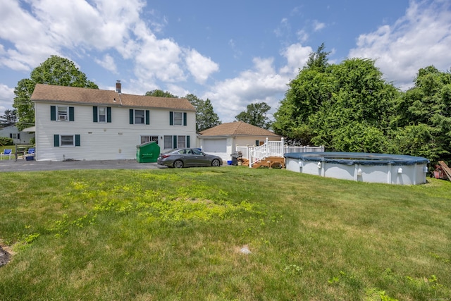 141 Peach Orchard Rd, Waterbury, CT 06706 - rear view of house with a covered pool, a garage, and a lawn