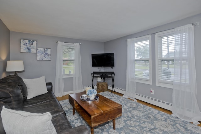 33 Old King St, Enfield, CT 06082 - living room with plenty of natural light, wood finished floors, and a baseboard radiator