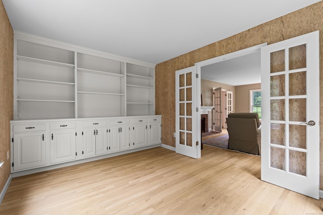 2 Applewood Cmn, East Lyme, CT 06333 - empty room featuring light wood-type flooring, french doors, and built in shelves