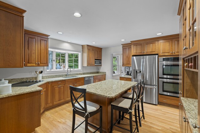 2 Applewood Cmn, East Lyme, CT 06333 - kitchen with stainless steel appliances, light wood finished floors, light stone counters, a kitchen bar, and recessed lighting