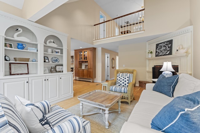 2 Applewood Cmn, East Lyme, CT 06333 - living room with light wood finished floors, baseboard heating, a towering ceiling, and a fireplace