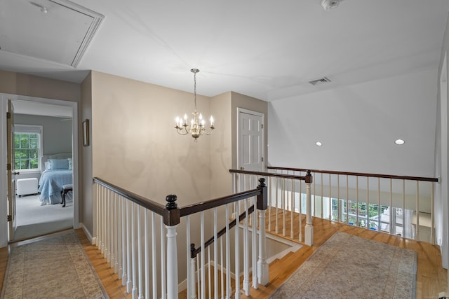 2 Applewood Cmn, East Lyme, CT 06333 - corridor featuring attic access, an upstairs landing, wood finished floors, and a chandelier